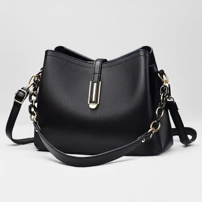 Elegant black crossbody bag with adjustable strap and gold hardware